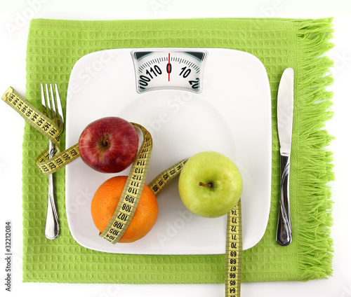 Photo: Fruits with measuring tape on a plate like weight scale Fruits with measuring tape on a plate like weight scale