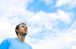 The young man looks at the blue sky..