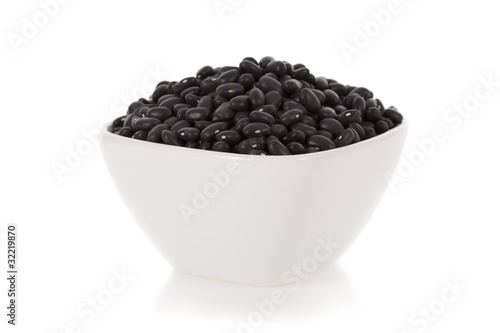 Photo: Black turtle beans in a bowl isolated on a white background. Black turtle beans in a bowl isolated on a white background.