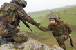 Soldier gives hand to his partner Soldier gives hand to his partner