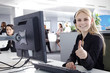Mitarbeiterin im Callcenter lächelt freundlich mit Daumen hoch Mitarbeiterin im Callcenter lächelt freundlich mit Daumen hoch
