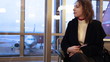 Video: woman sitting by window airport with documents in hand woman sitting by window airport with documents in hand