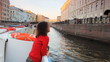 pretty girl floats in boat on river channel to St. Petersburg