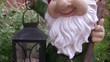 Sculpture of dwarf with lamp in hands in garden.