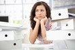 Pretty secretary sitting among folders in bad mood