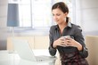 Foto: Young female browsing internet at home smiling Young female browsing internet at home smiling
