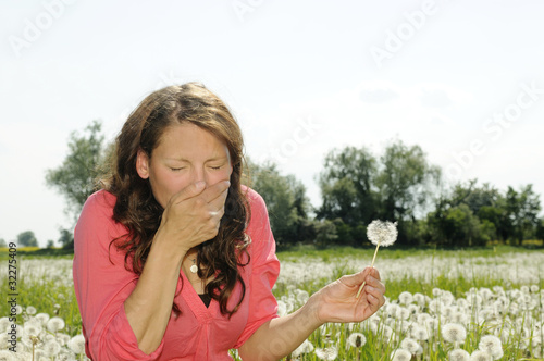 Foto: junge frau niest auf einer blumenwiese junge frau niest auf einer blumenwiese