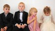 Four children in celebratory clothes sit in room