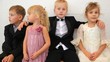 Four children in celebratory clothes sit in room
