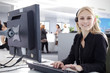 Mitarbeiterin im Callcenter mit Head Set telefoniert freundlich