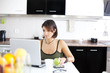 Modern woman reading e-mails at her breakfast
