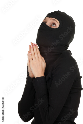 Photo: praying female thief in black clothes and balaclava praying female thief in black clothes and balaclava
