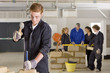 Foto: Student hammering chisel on brick in vocational school Student hammering chisel on brick in vocational school
