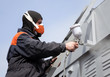 Photo: A commercial painter on the stairs spray painting a steel exteri A commercial painter on the stairs spray painting a steel exteri