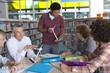 Foto: Teacher explaining wind turbine models to students in school library Teacher explaining wind turbine models to students in school library