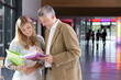 Teacher helping student studying in school hallway