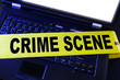 laptop with yellow crime scene tape across it