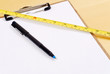 Pen on Clipboard with Construction Tape Measure