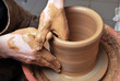 hands of a potter, creating an earthen jar on the circle
