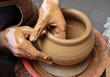 hands of a potter, creating an earthen jar on the circle