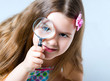 little girl looking through a magnifying glass