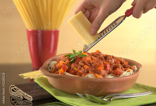Photo: Grating cheese over spaghetti bolognaise Grating cheese over spaghetti bolognaise
