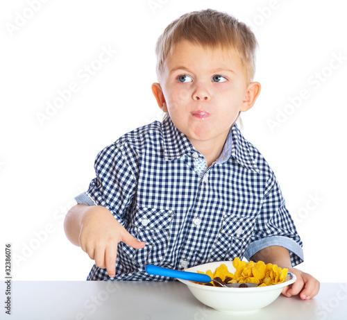 Photo: A boy is eating cereal from a bowl A boy is eating cereal from a bowl