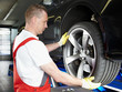 Foto: Motor mechanic is changing a summer tyre in a garage Motor mechanic is changing a summer tyre in a garage