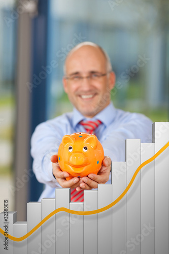 Photo: lächelnder mann mit sparschwein und säulendiagram lächelnder mann mit sparschwein und säulendiagram