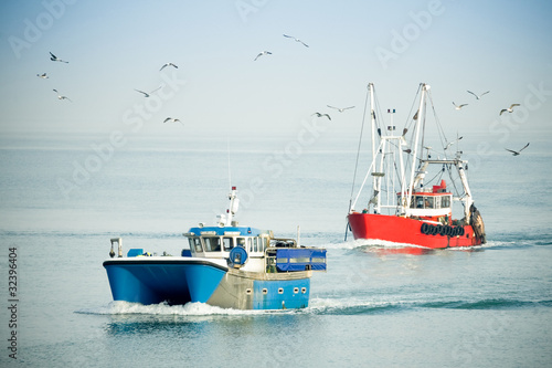 Photo: fishing trawlers returning to port on a hazy day fishing trawlers returning to port on a hazy day