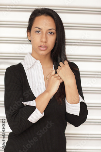Photo: Attractive Hispanic female touching her hair Attractive Hispanic female touching her hair