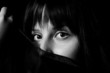 Young arabic girl hiding her face with a scarf in black and whit
