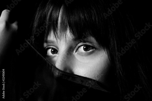 Photo: Young arabic girl hiding her face with a scarf in black and whit Young arabic girl hiding her face with a scarf in black and whit