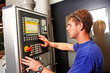 skilled worker controlling a digitally programmed machine tool
