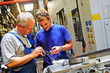 skilled workers controlling a workpiece
