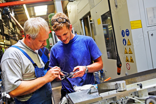 Photo: skilled workers controlling a workpiece skilled workers controlling a workpiece