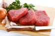Raw beef on cutting board on white background