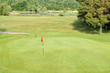 Putting green and flag on golf course Putting green and flag on golf course
