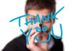 Young man writing Thank YOU on whiteboard
