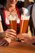 Paar in Tracht stößt mit Weißbier an