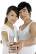 Happy asian couple drinking a glass of water