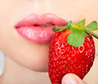 woman's mouth with red strawberry covered with sugar woman's mouth with red strawberry covered with sugar