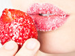 woman's mouth with red strawberry covered with sugar woman's mouth with red strawberry covered with sugar