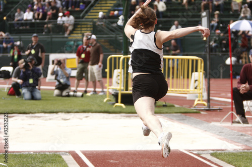 Photo: Female athlete competing on the "long jump" event Female athlete competing on the "long jump" event
