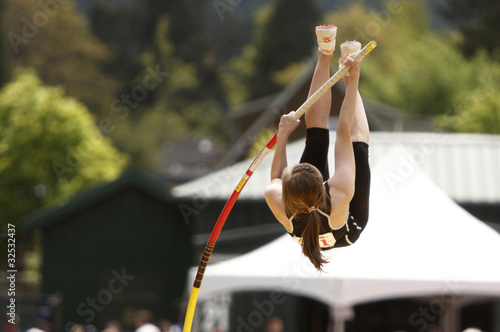Photo: Female athlete competing in the pole vault Female athlete competing in the pole vault