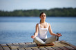 beautiful young girl training yoga near a lake beautiful young girl training yoga near a lake