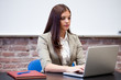 Teacher using laptop at desk in classroom
