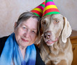 Portrait of a woman and dog with party hats