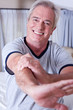 Smiling senior man stretching