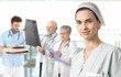 Mid-adult nurse with medical team in background